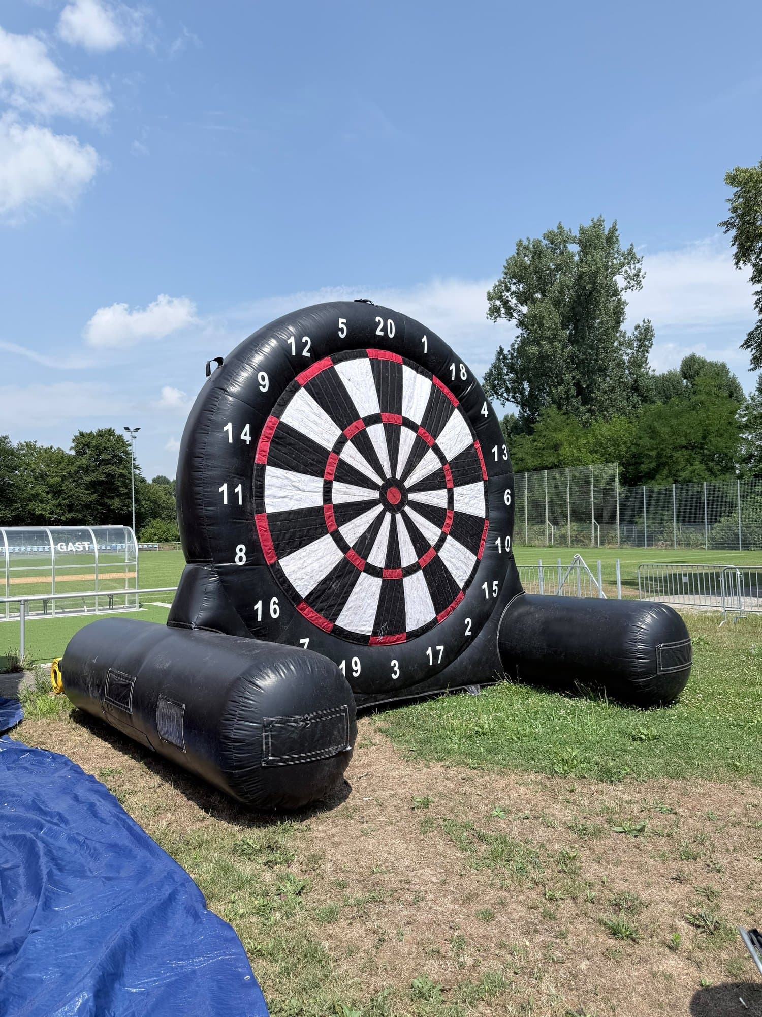 Aufblasbare Riesen-Dartscheibe auf einer Wiese am Sportplatz